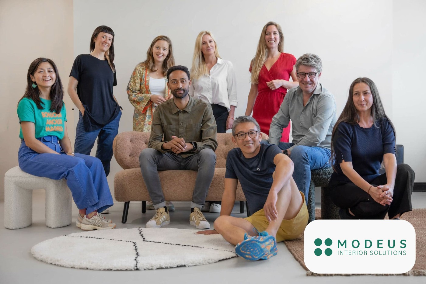 Portrait de l’équipe Modeus avec les membres du groupe assis et debout dans un studio lumineux